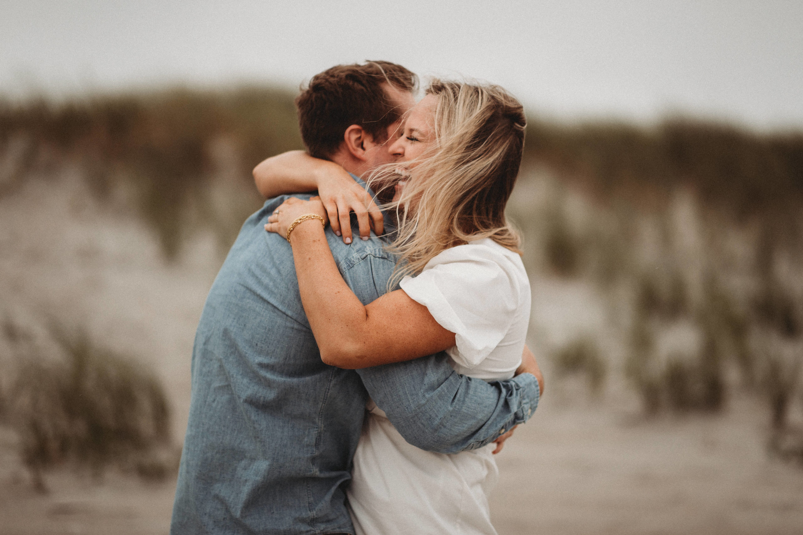 Couple hugging at beach during engagement session