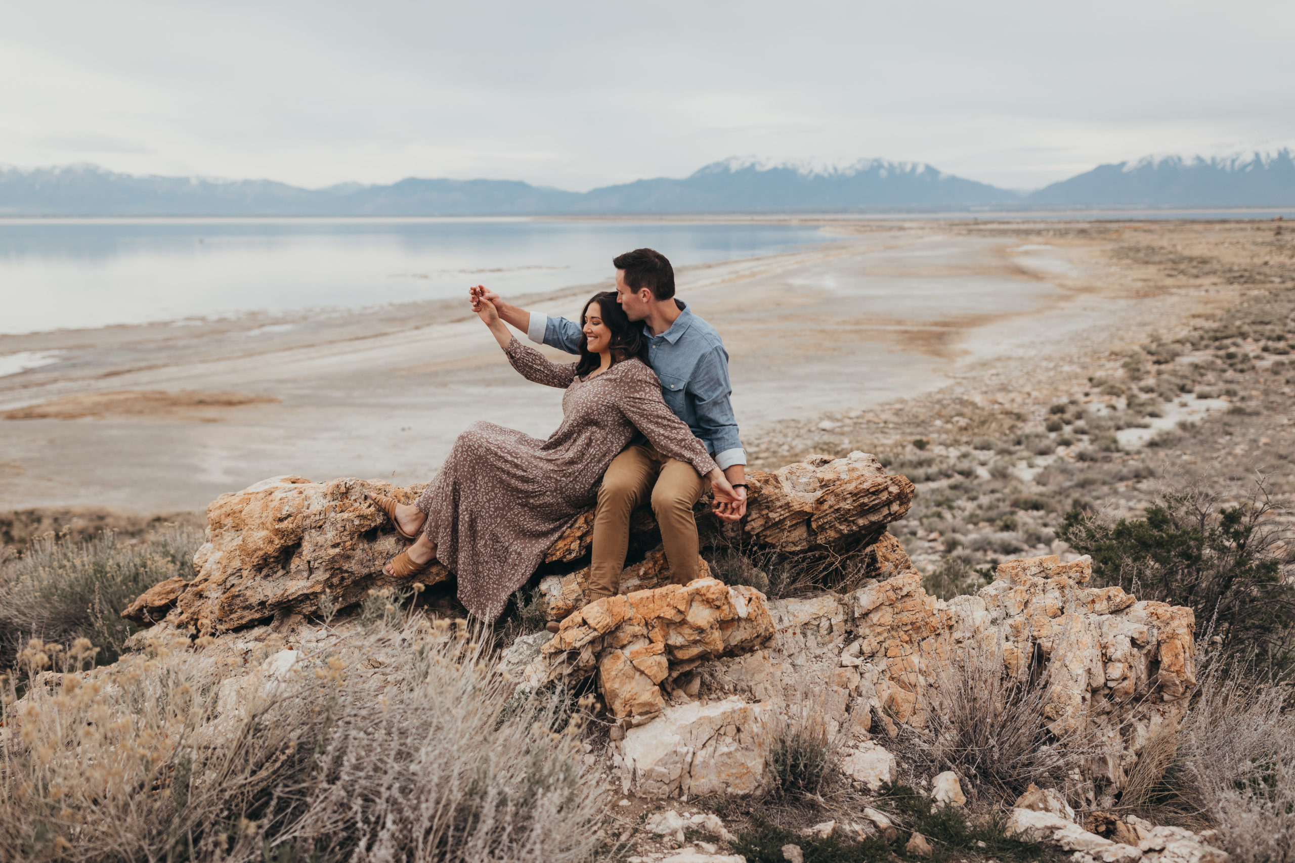 Couple sitting down and smiling during engagement session in Utah