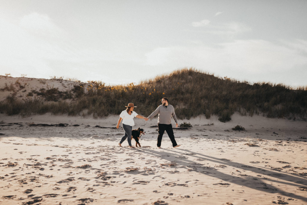 Couple walking along beach at engagement session