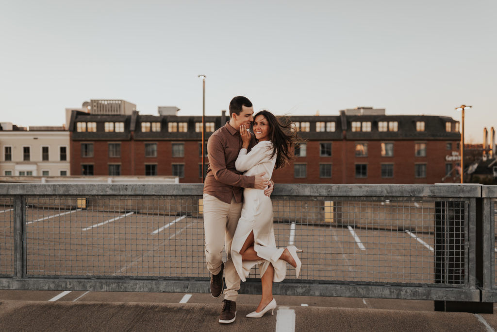 Couples in neutral outfits at rooftop engagement session