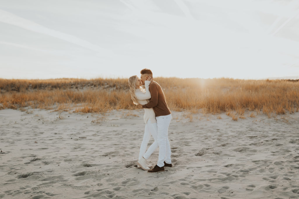 Couple dressed in neutral colors at beach engagement session