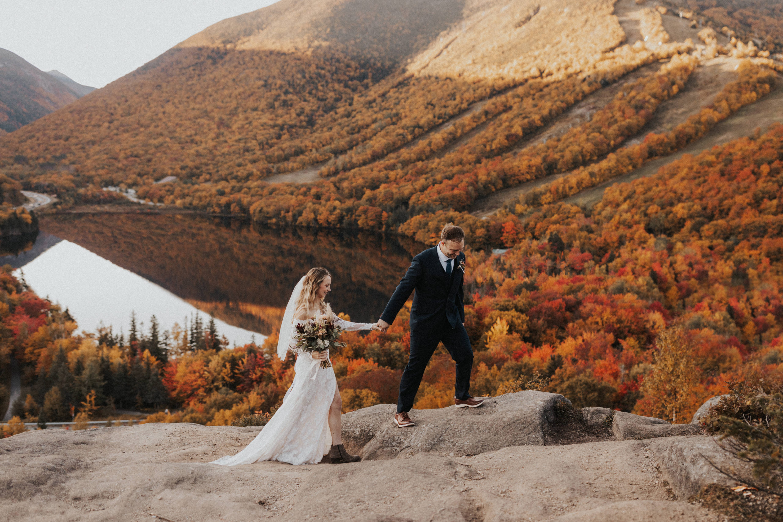 Bride and Groom walking on top of Artists Bluff during a fall elopement in the White Mountains of NH
