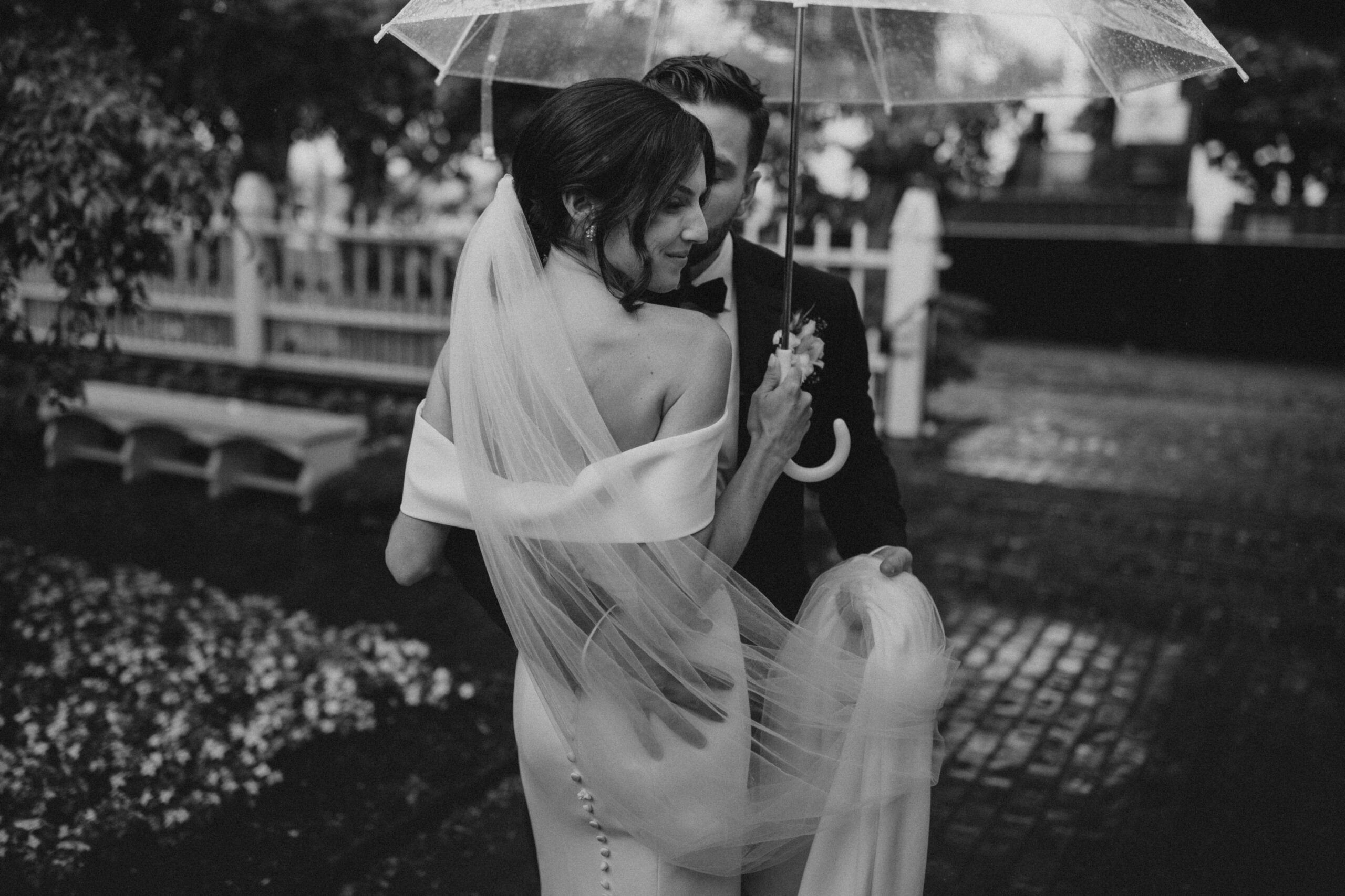 Black and white image of bride and groom at Prescott Park in Portsmouth, NH on their rainy wedding day