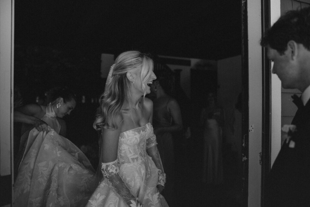 Black and white candid photo of bride smiling on her wedding day at Scotland Fields in York, Maine.